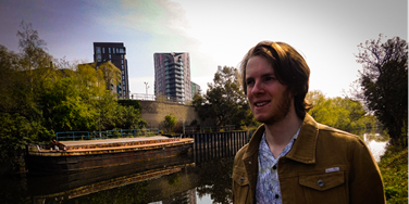 Oli standing by Leeds waterfront