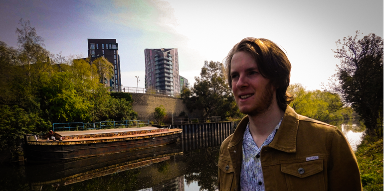 Oli standing by Leeds waterfront